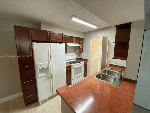 a kitchen with a refrigerator sink and stove