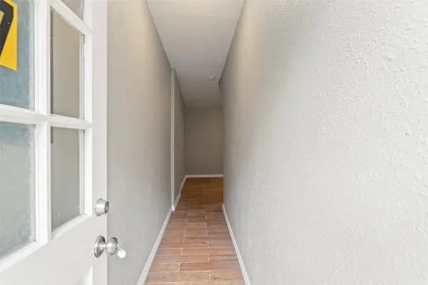 a view of a hallway with wooden floor and entryway