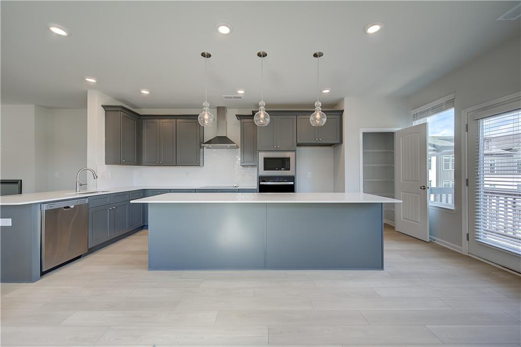 313 Daybreak Lane Newnan, GA 30265 - Photo 11 of 26 a large kitchen with stainless steel appliances kitchen island a large counter top and a sink