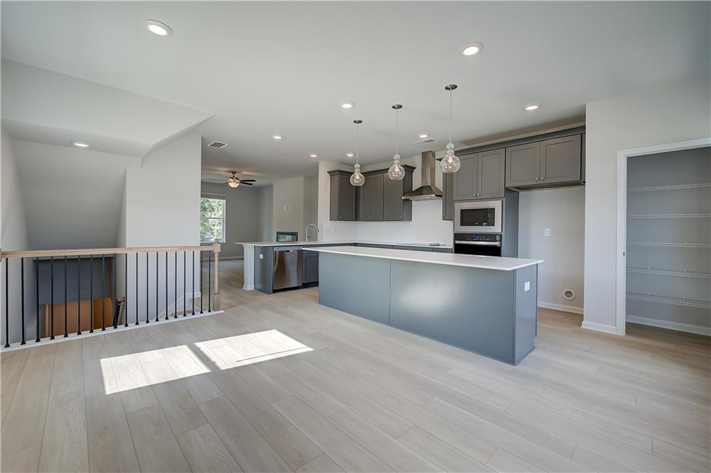 313 Daybreak Lane Newnan, GA 30265 - Photo 12 of 26 a large kitchen with stainless steel appliances kitchen island granite countertop a large counter top and wooden floors