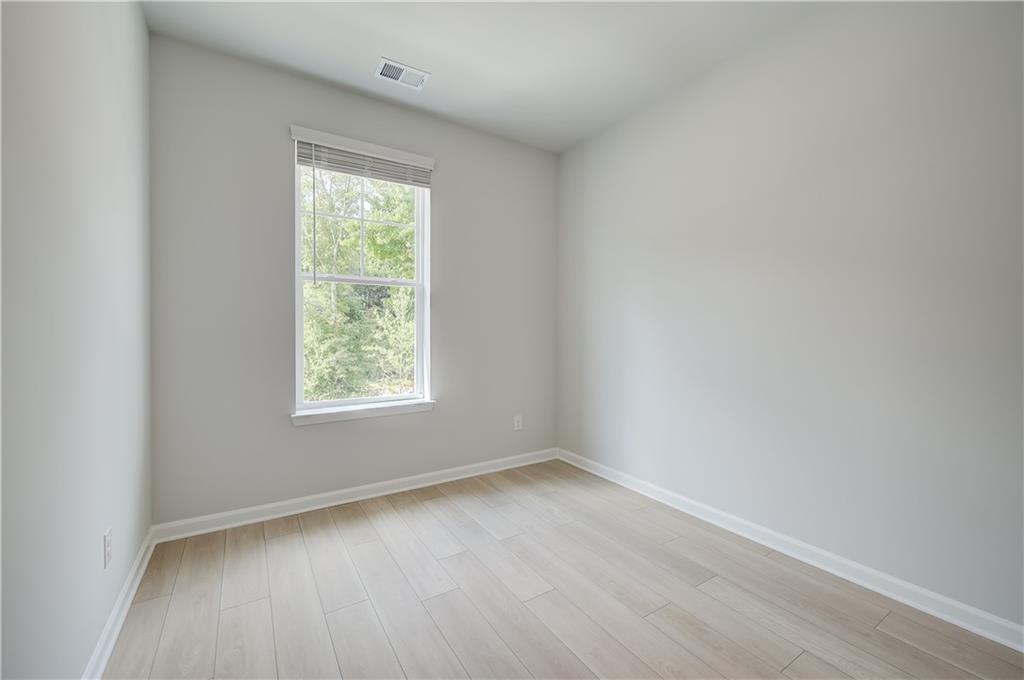 313 Daybreak Lane Newnan, GA 30265 - Photo 20 of 26 an empty room with wooden floor and windows
