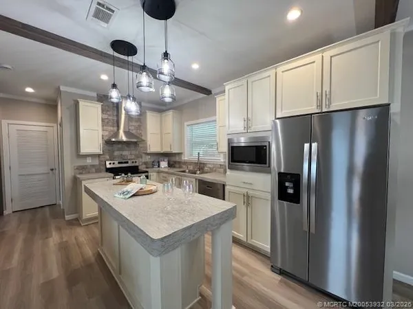 a kitchen with stainless steel appliances white cabinets and a sink