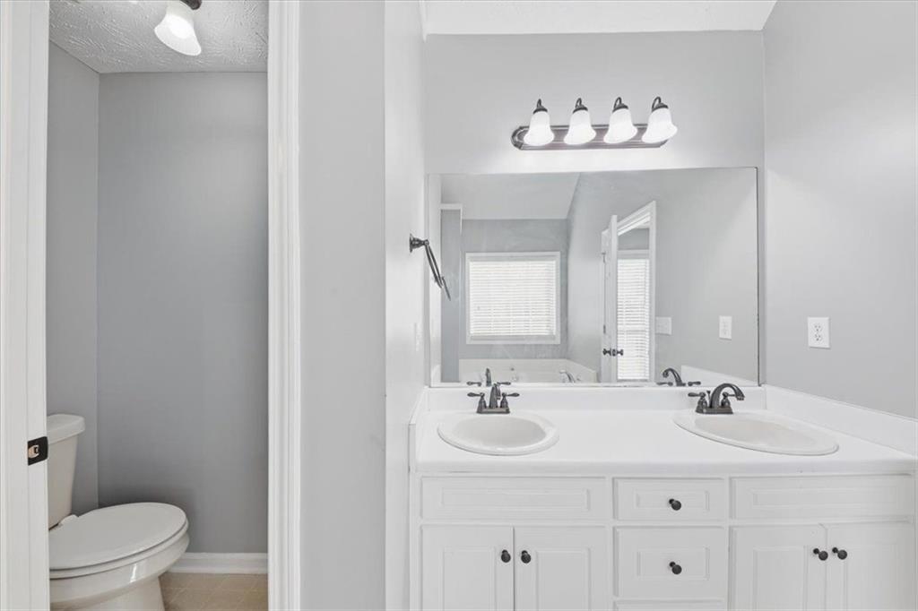 493 Youth Jersey Road Covington, GA 30014 - Photo 32 of 52 a bathroom with a sink a toilet and a mirror