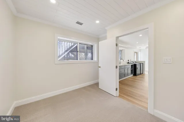 wooden floor in an empty room with a kitchen