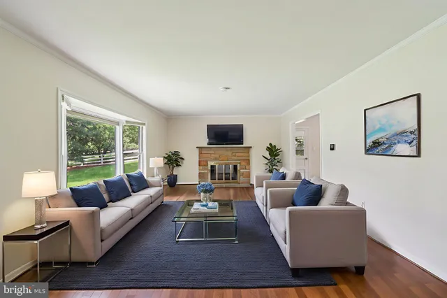 a living room with furniture fireplace and a large window