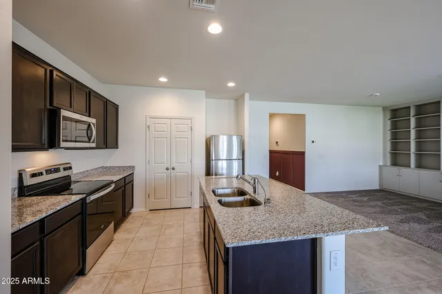 a kitchen with stainless steel appliances granite countertop a stove a sink and a refrigerator