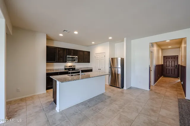 a kitchen with stainless steel appliances granite countertop a refrigerator and a stove