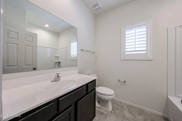a bathroom with a sink mirror and toilet