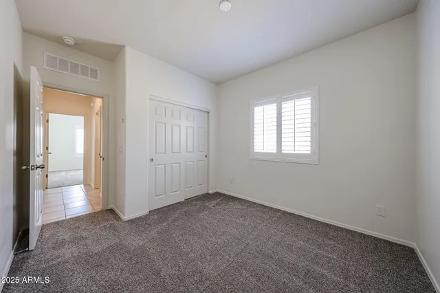 an empty room with windows and closet
