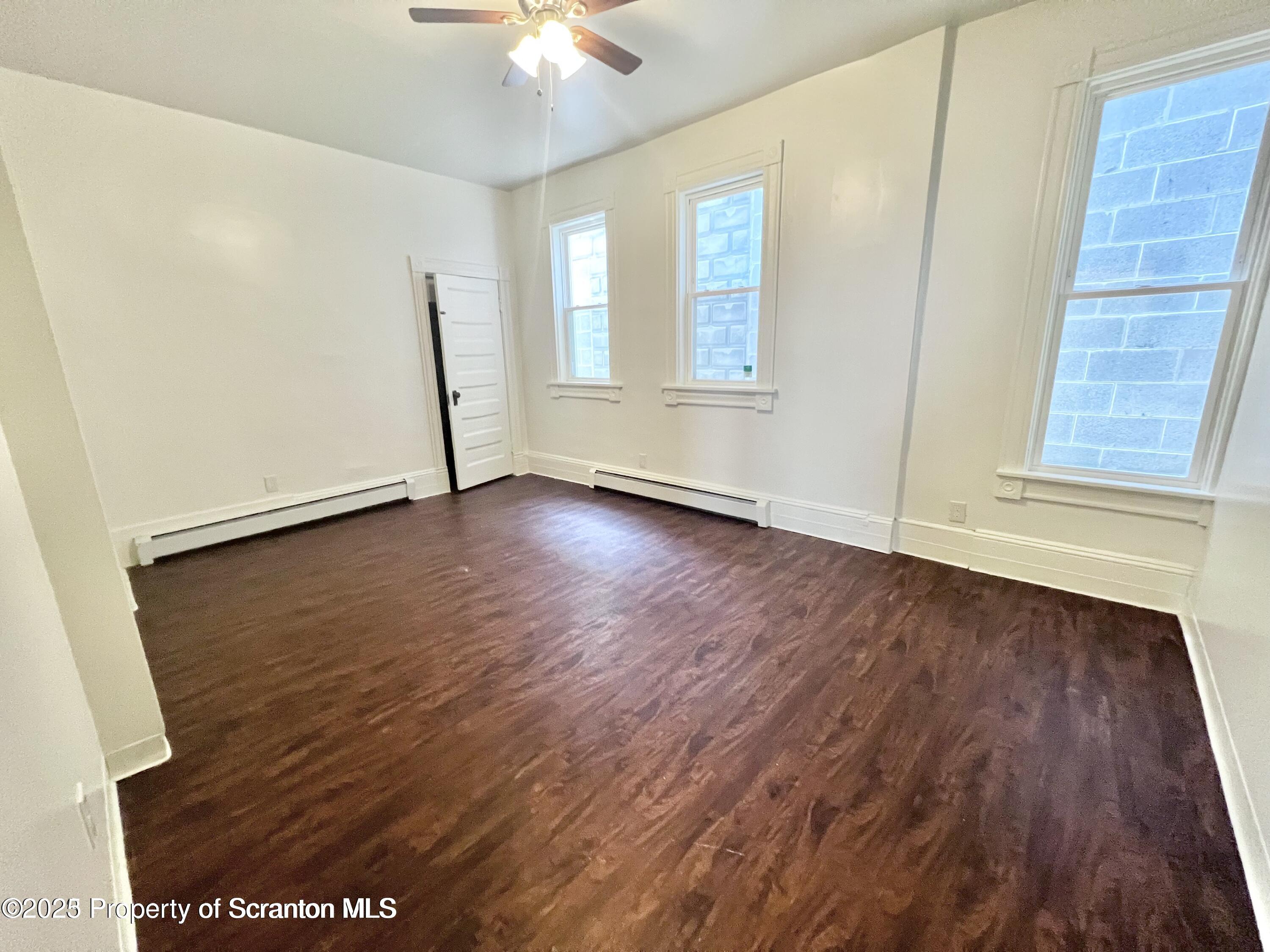 1930 Boulevard Avenue, Unit 1 Scranton, PA 18509 - Photo 5 of 9 an empty room with wooden floor and windows