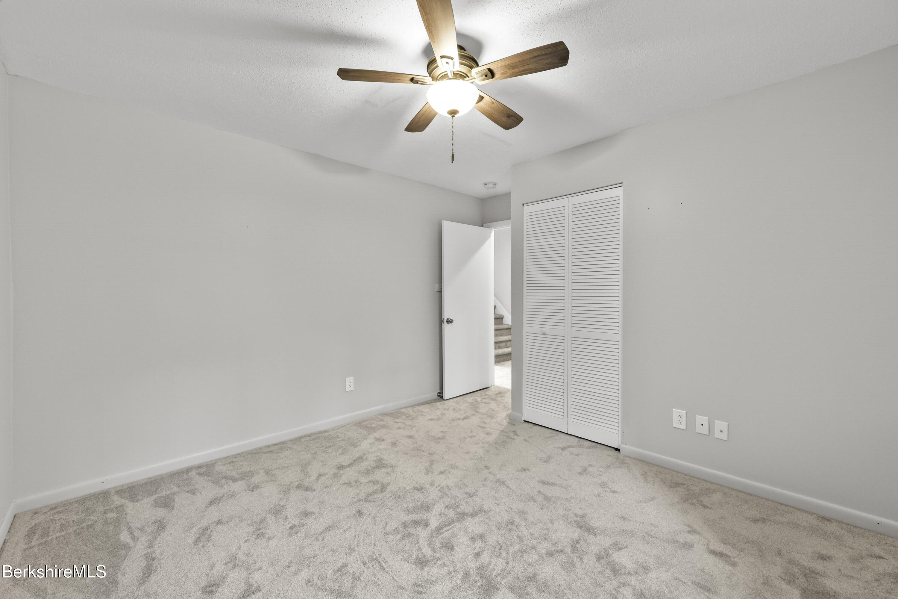 94 Corey Road, Unit D Hancock, MA 01237 - Photo 15 of 45 an empty room with a chandelier fan and closet