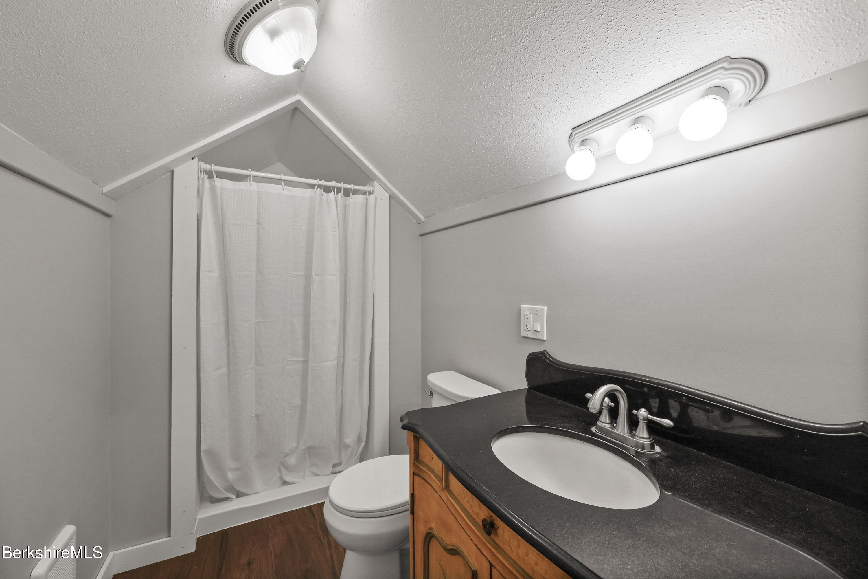 94 Corey Road, Unit D Hancock, MA 01237 - Photo 22 of 45 a bathroom with a granite countertop sink toilet a mirror and shower curtain