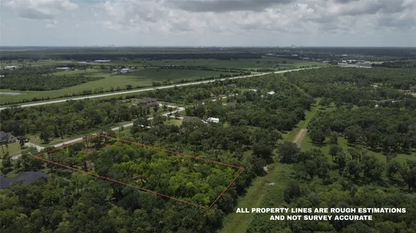 an aerial view of residential houses with outdoor space and trees