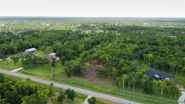 an aerial view of residential houses with outdoor space and trees
