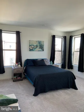a bedroom with a bed couch and a large window