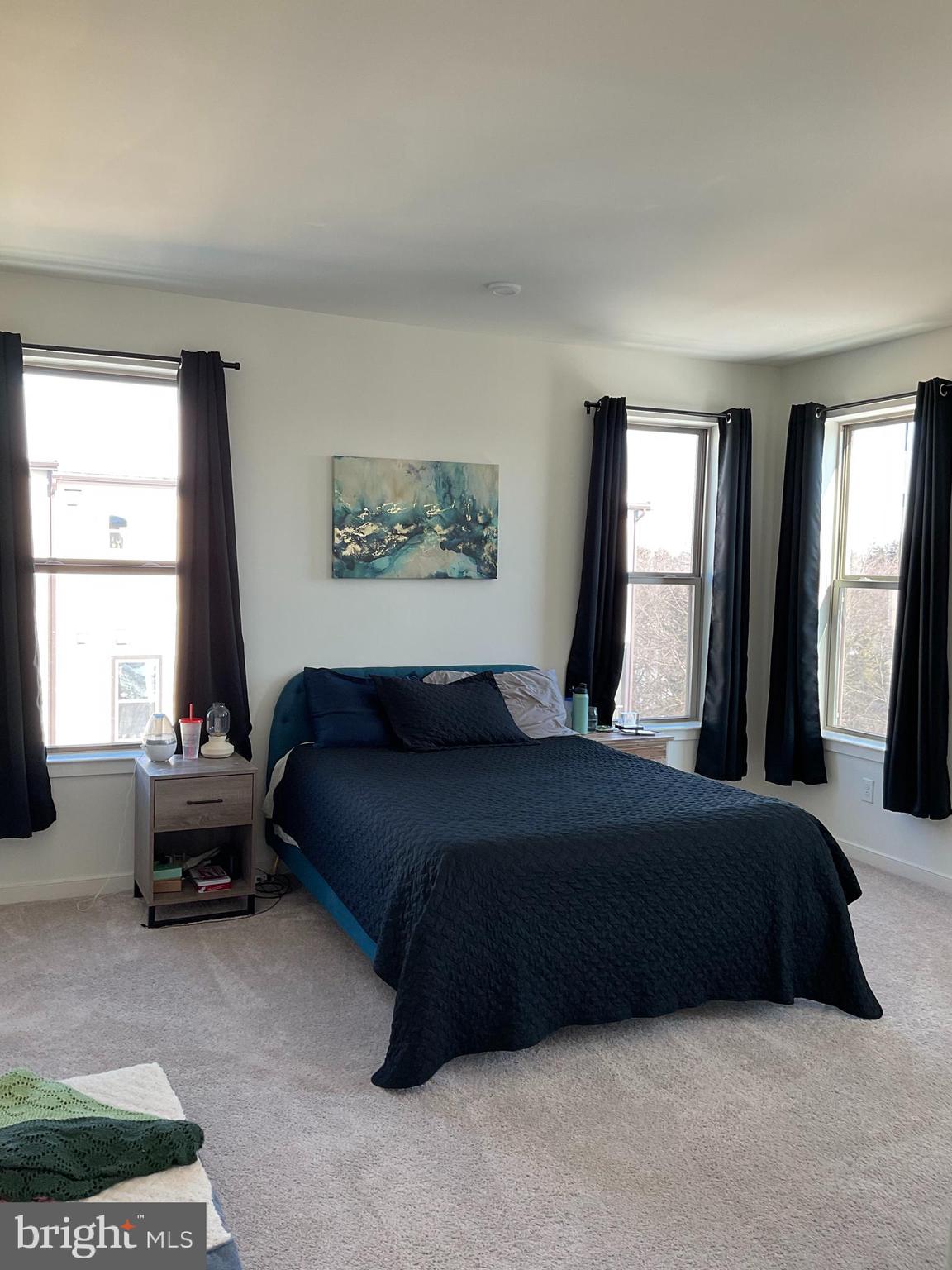 45968 Swallow Terrace Sterling, VA 20165 - Photo 17 of 27 a bedroom with a bed couch and a large window