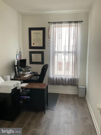 a view of a workspace with furniture and a window