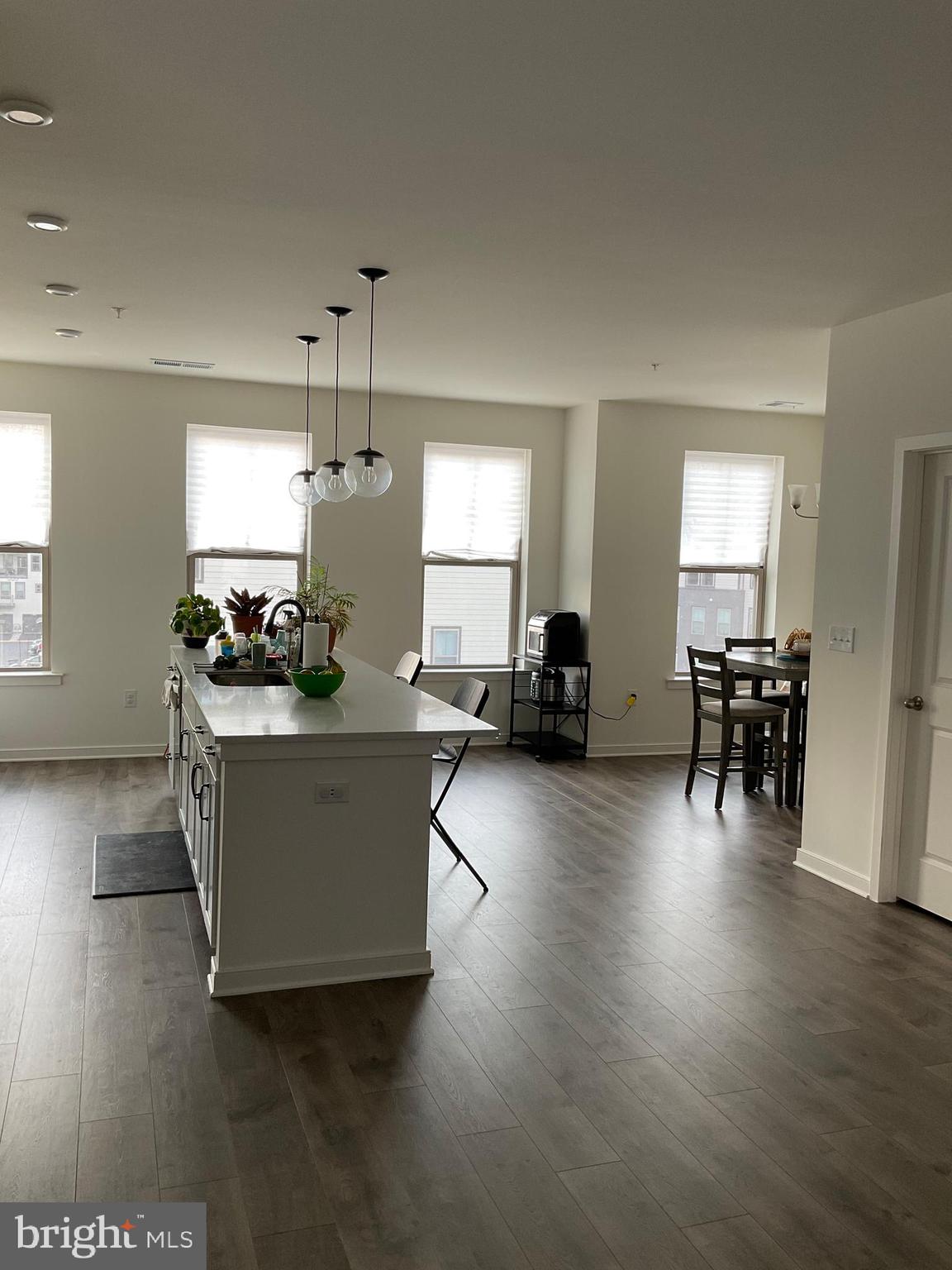 45968 Swallow Terrace Sterling, VA 20165 - Photo 23 of 27 a living room with couches and kitchen view with wooden floor
