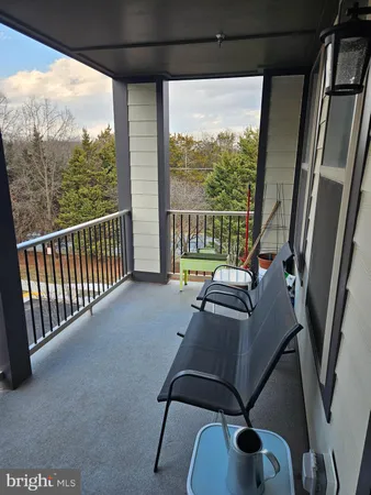 a balcony with furniture and a floor to ceiling window