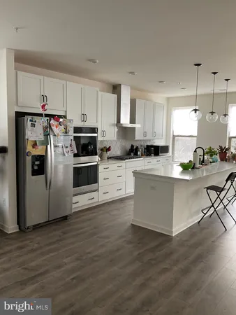 a kitchen with stainless steel appliances a stove a sink and white cabinets