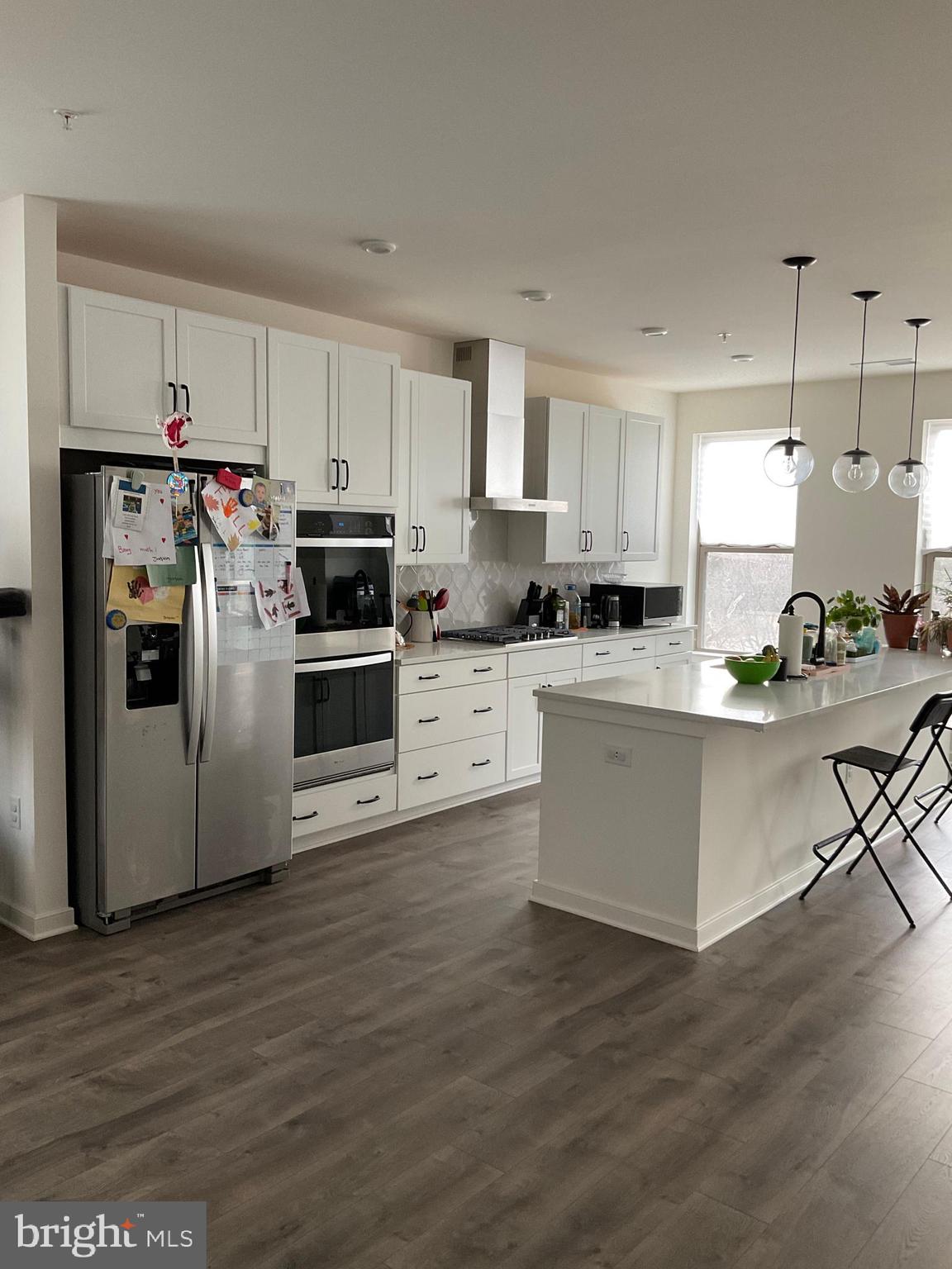 45968 Swallow Terrace Sterling, VA 20165 - Photo 3 of 27 a kitchen with stainless steel appliances a stove a sink and white cabinets