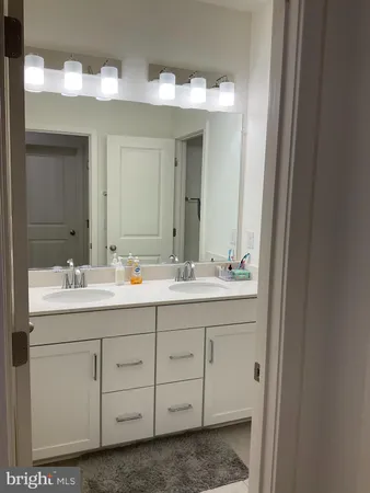 a bathroom with a double vanity sink and a mirror