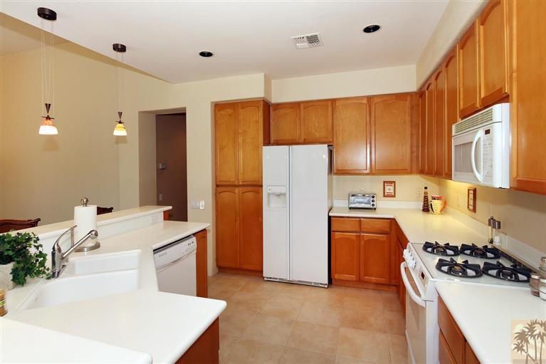 78780 Rio Seco La Quinta, CA 92253 - Photo 13 of 37 a kitchen with a sink a stove and refrigerator