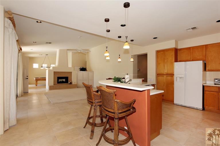 78780 Rio Seco La Quinta, CA 92253 - Photo 17 of 37 a kitchen with stainless steel appliances a stove a refrigerator a oven a sink with a dining table and chairs