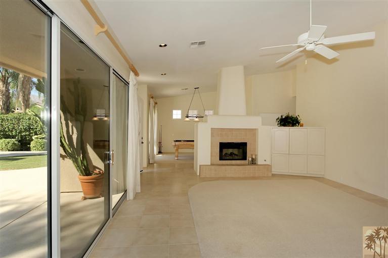 78780 Rio Seco La Quinta, CA 92253 - Photo 18 of 37 a view of a livingroom with a fireplace a ceiling fan and windows