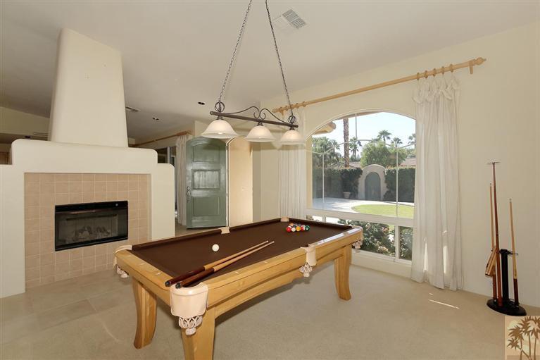 78780 Rio Seco La Quinta, CA 92253 - Photo 20 of 37 a living room with furniture a fireplace and a chandelier