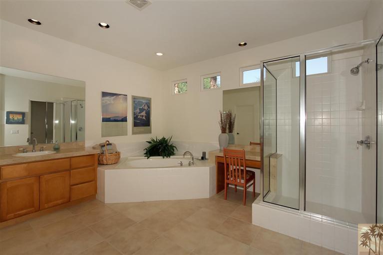 78780 Rio Seco La Quinta, CA 92253 - Photo 26 of 37 a bathroom with a bathtub a double vanity sink and a large mirror