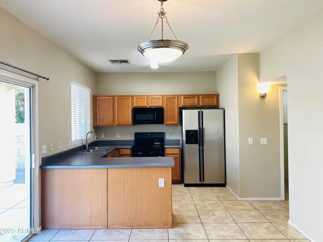 a kitchen with stainless steel appliances granite countertop a refrigerator a sink and a stove