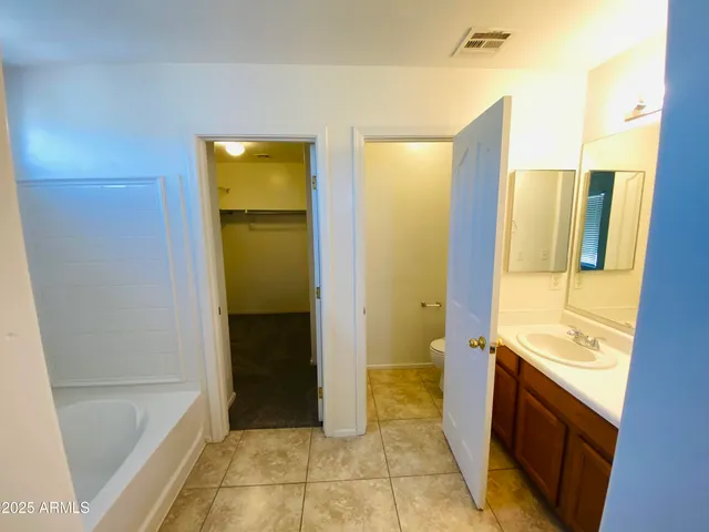 a bathroom with a granite countertop sink a mirror and a bathtub