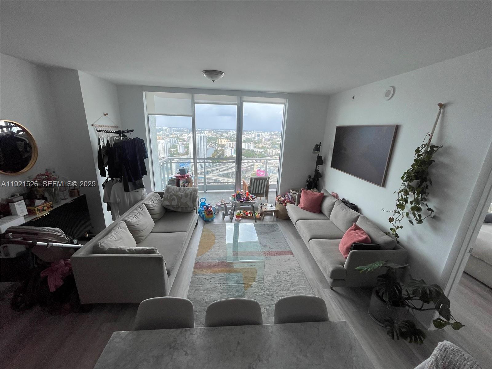 90 Southwest 3rd Street, Unit 4105 Miami, FL 33130 - Photo 11 of 27 a living room with furniture and a flat screen tv