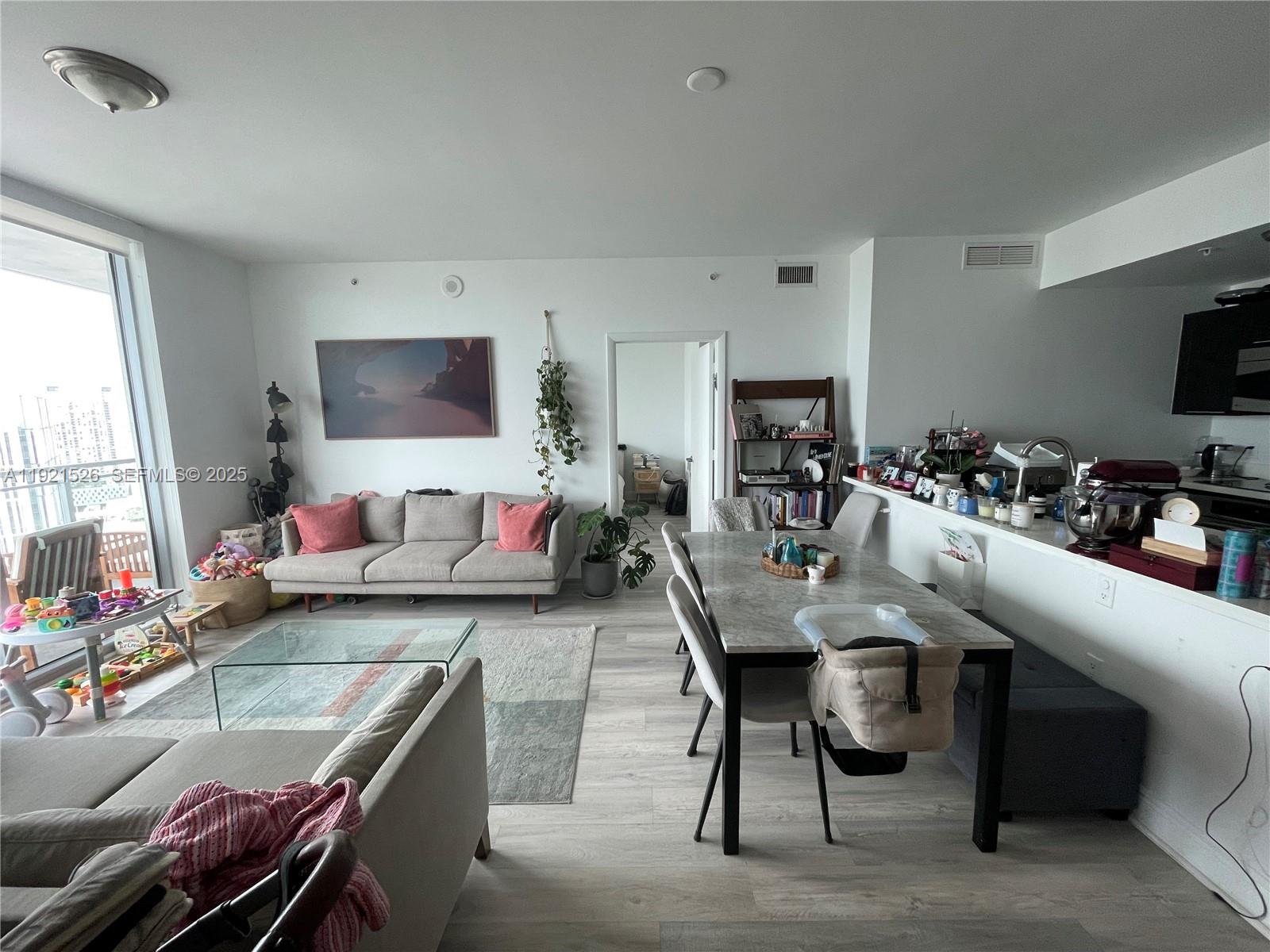 90 Southwest 3rd Street, Unit 4105 Miami, FL 33130 - Photo 12 of 27 a living room with furniture and a flat screen tv