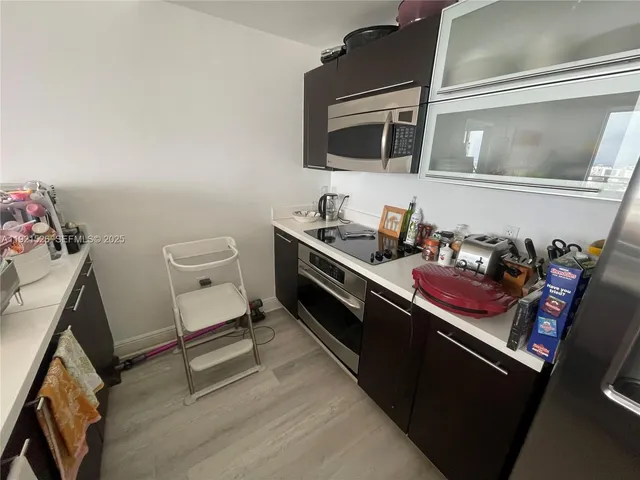 a kitchen with granite countertop a refrigerator and a sink