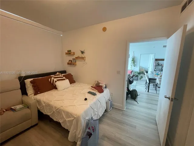 a bedroom with a bed a couch and a large window