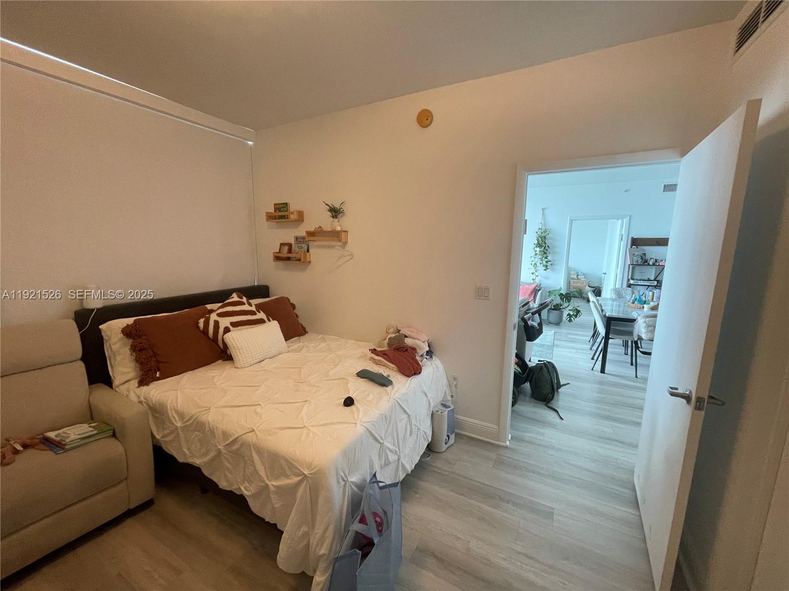 90 Southwest 3rd Street, Unit 4105 Miami, FL 33130 - Photo 20 of 27 a bedroom with a bed and wooden floor