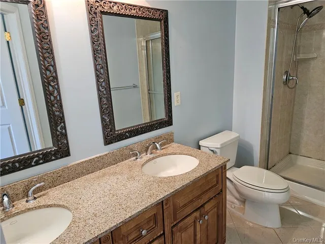 a bathroom with a granite countertop sink toilet and mirror