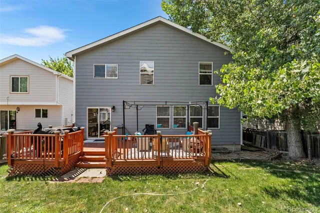 a view of a house with wooden deck and a yard