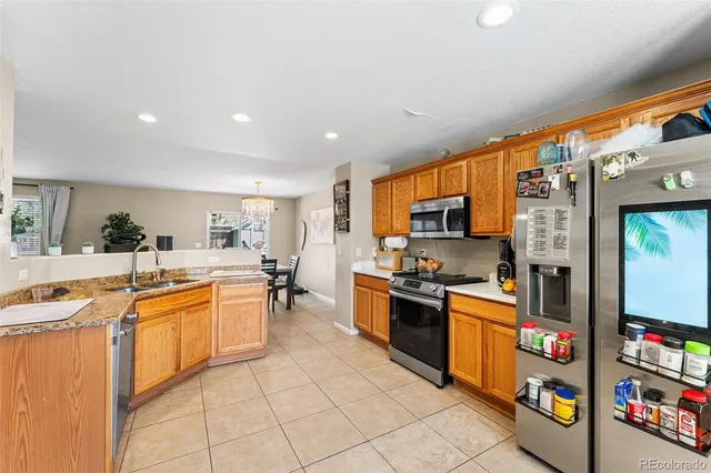 a large kitchen with stainless steel appliances granite countertop a lot of counter space and a sink