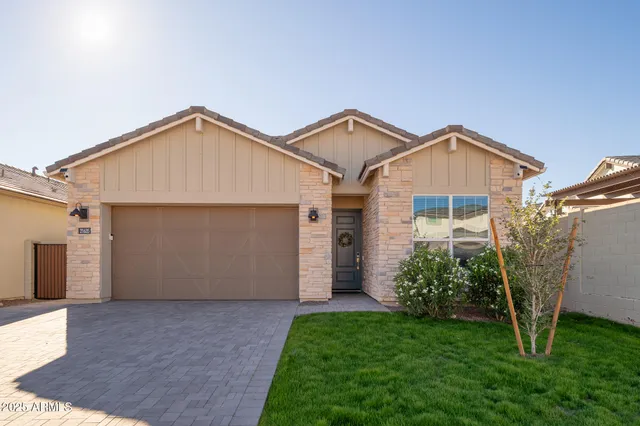 a view of a house with a small yard and a large parking space