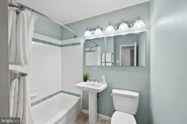 a bathroom with a sink mirror and a toilet