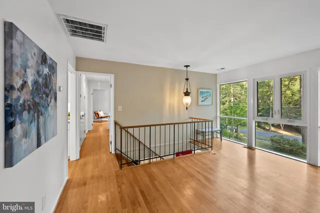 a view of a hallway with wooden floor and windows