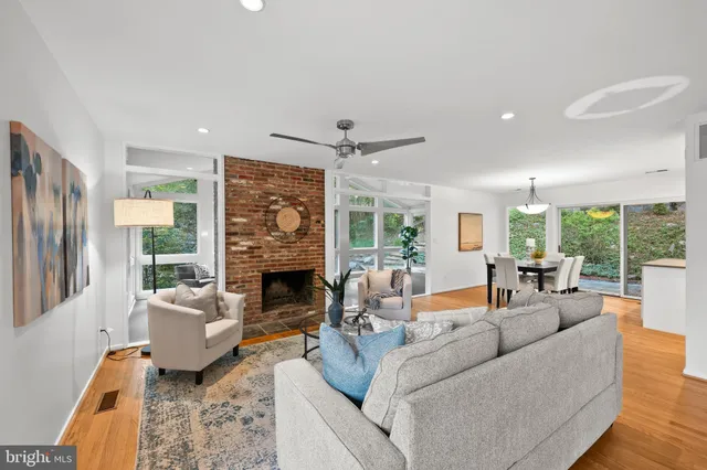 a living room with fireplace furniture large windows and a fireplace