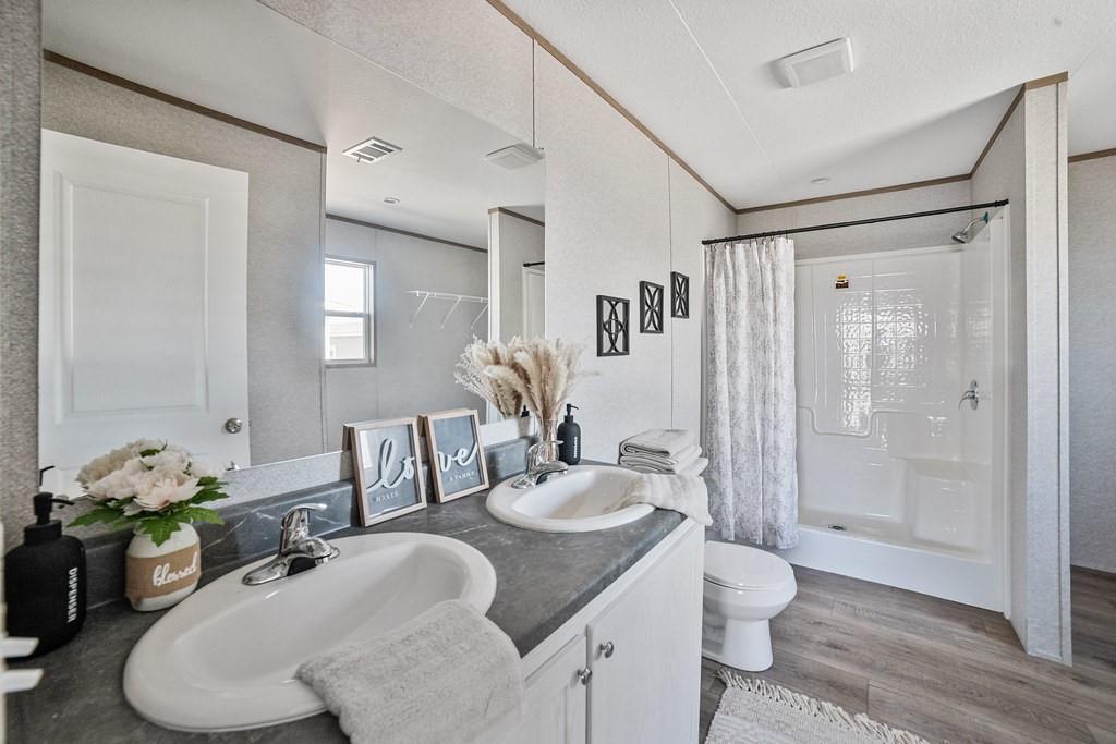 164 Ranya Loop Decatur, TX 76234 - Photo 20 of 31 a bathroom with a granite countertop sink a toilet and shower
