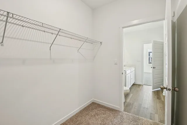 a view of a room with a walk in closet and wooden floor