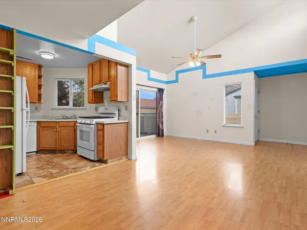 a view of kitchen with stainless steel appliances granite countertop a stove a refrigerator and a view of living room