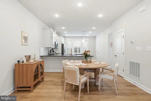 a kitchen with stainless steel appliances kitchen island granite countertop a sink a stove a dining table and chairs