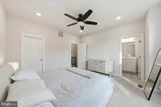 a bedroom with a large bed and a ceiling fan